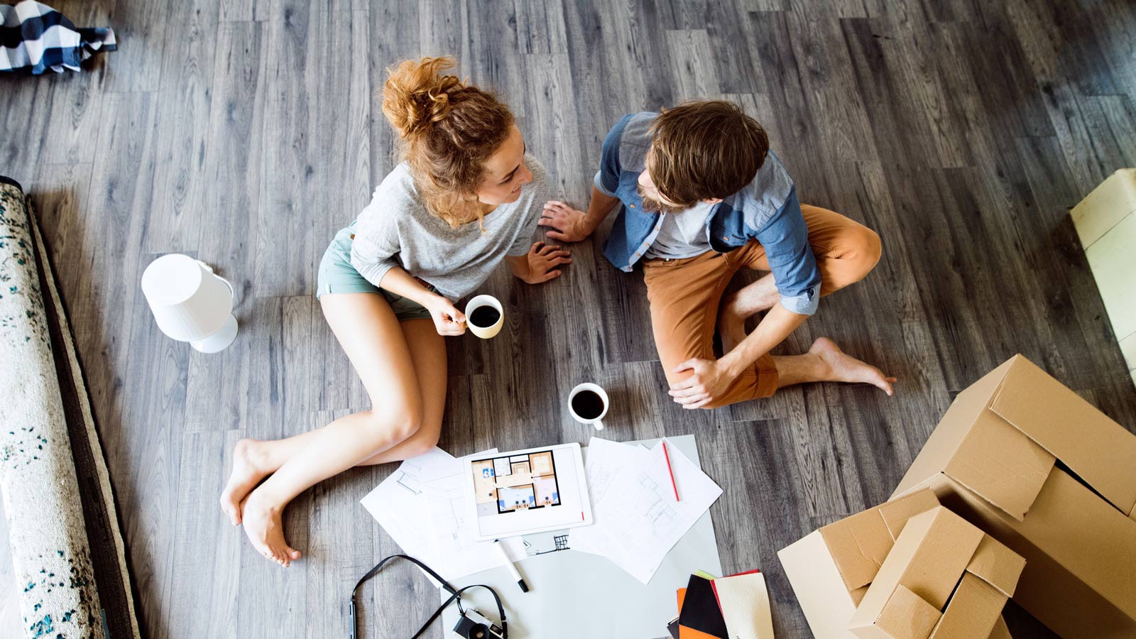 Par sidder blandt flyttekasser