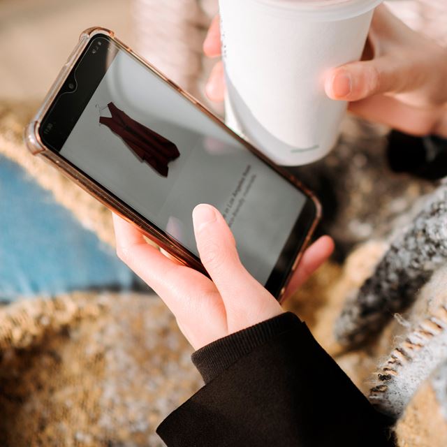Nærbillede af mobil hvor kvinde shopper tøj
